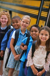 Smiling Children by School Bus