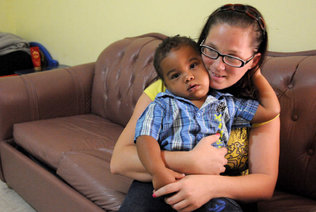 Ashley Maddox hugs her son, Miguel Romero III, who will be 2 in December, n her Little Havana apartment before leaving for work. [Photo: Marice Cohn Band/ Miami Herald Staff]